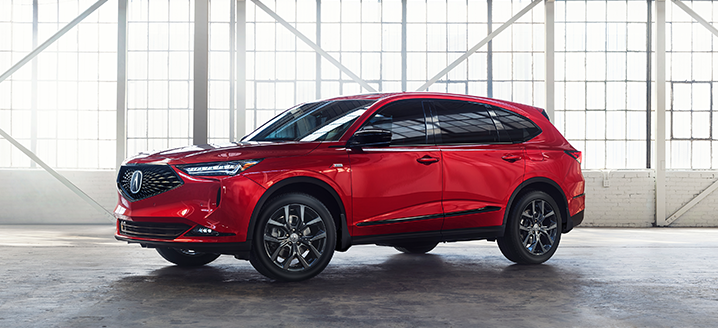 Side view of a red MDX in a bright, spacious warehouse / Vue latérale d’un MDX rouge dans un entrepôt spacieux et lumineux
