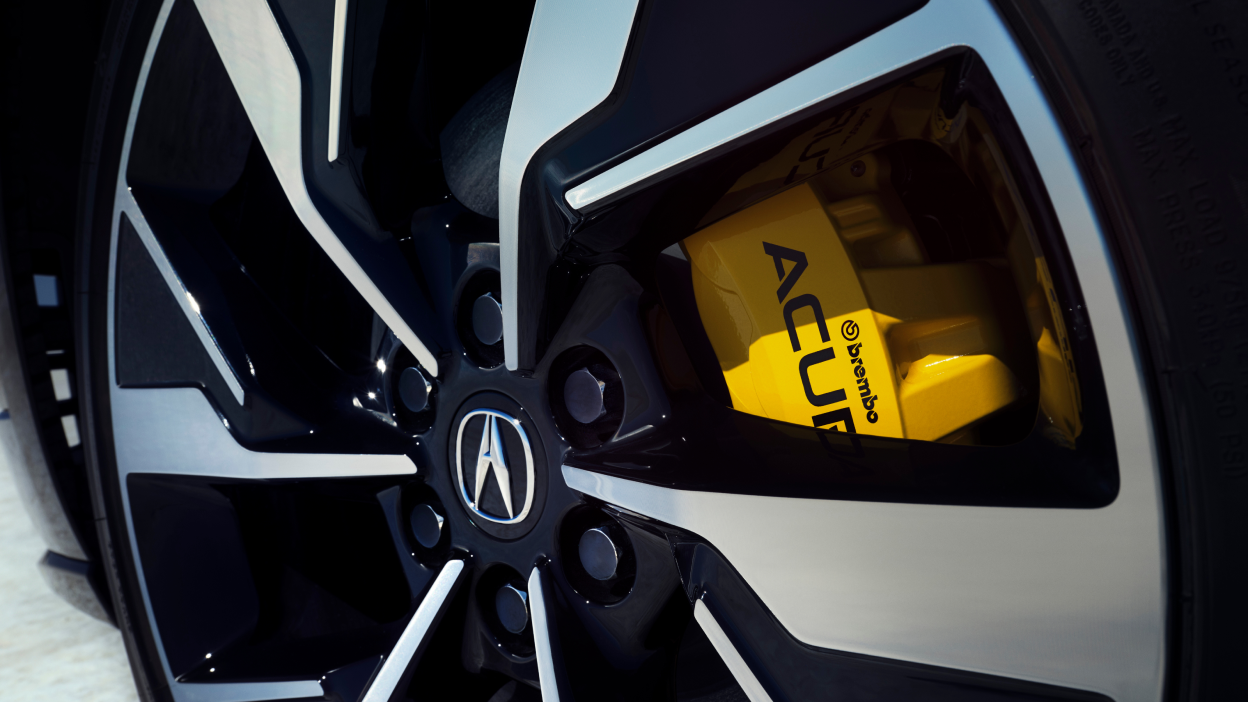 Macro closeup of wheel showcasing the yellow brake caliper.