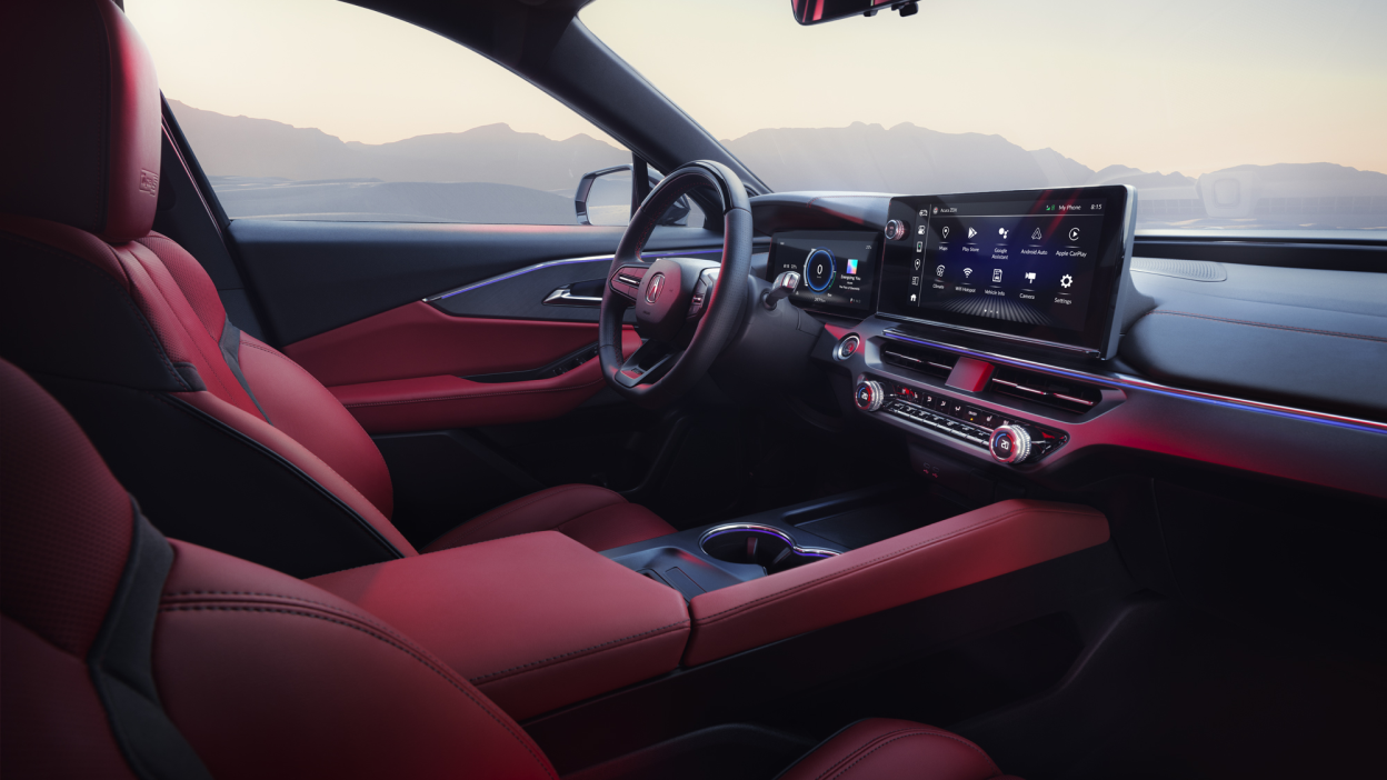 Wide interior view of driver’s side of the cockpit, including leather-wrapped steering wheel, digital instrument cluster, and touchscreen.