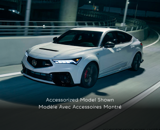 3/4 front side view of white Integra Type S taking a turn on a highway onramp at night.